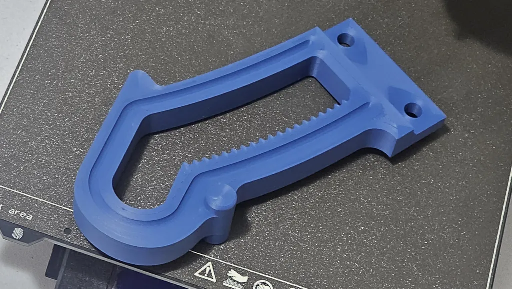 Blue 3D-printed replacement part on a printer bed